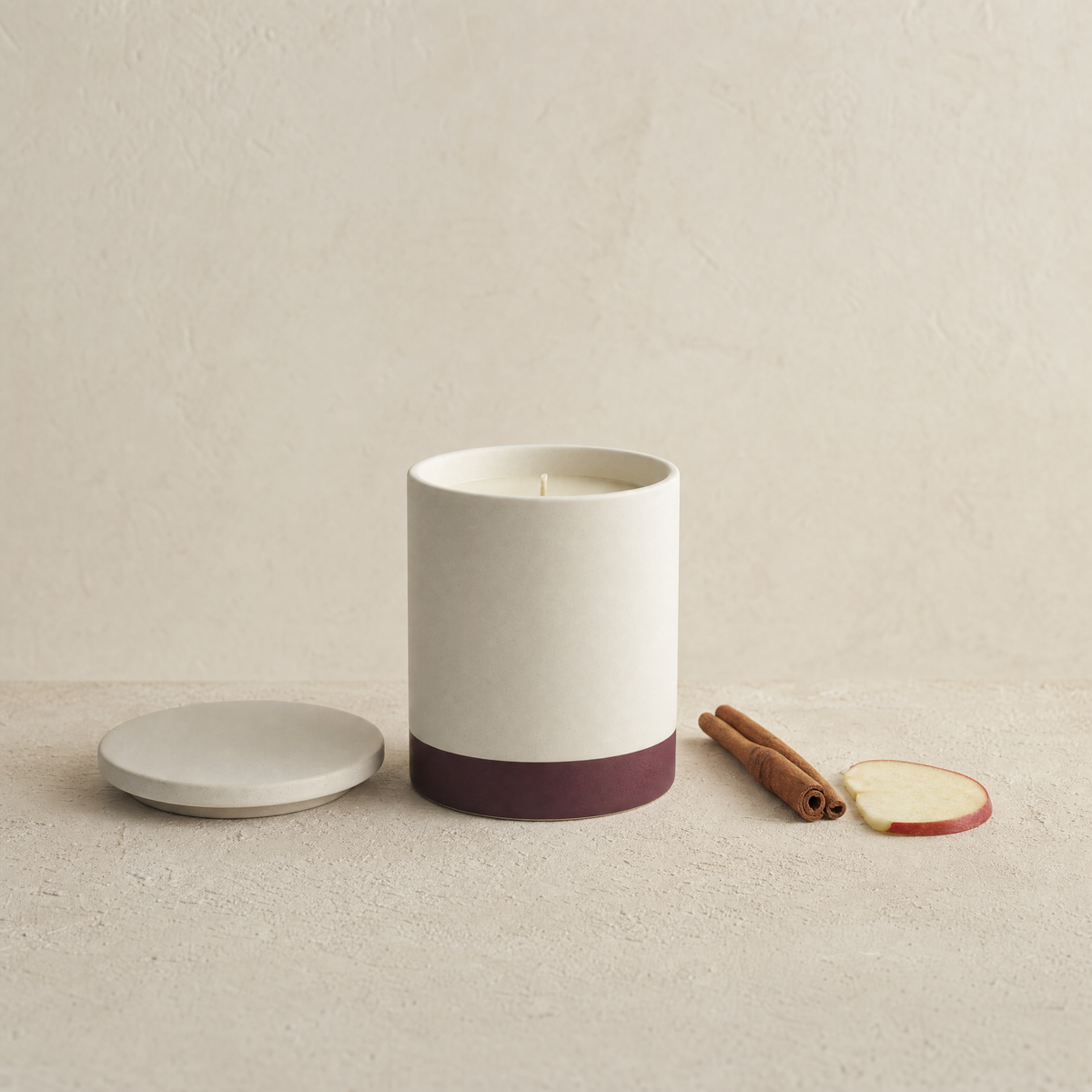 Cinnamon apple soy candle with cinnamon sticks and a slice of red apple