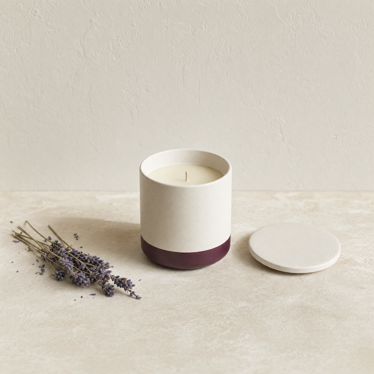 Lavender soy candle in a matte off-white ceramic vessel with dried lavender stems